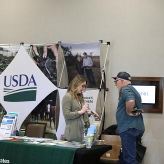 NRCS employee speaking to producer at an event