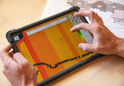 Precision ag technology shown on a tablet, with view of hands.