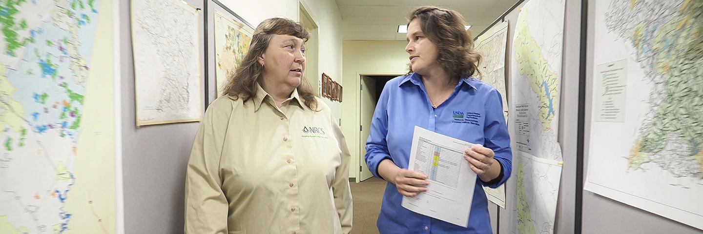 Two NRCS team members discuss a conservation application.