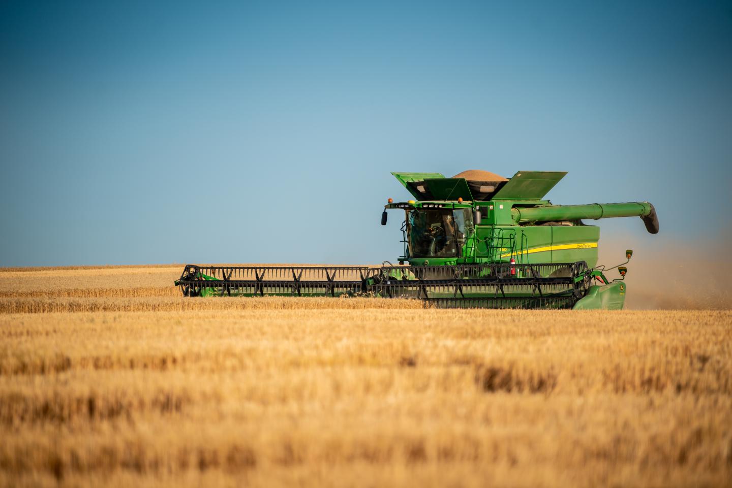 A combine moves across a field during harvest.