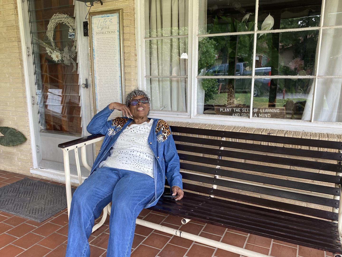 Opal Lee enjoying spending time on her porch. The sign facing visitors says: "Plant the Seeds of learning and grow a mind." It pretty much wraps up Lee’s lifelong efforts as an educator, as well as her efforts growing healthy food for her community at Opal’s Farm.