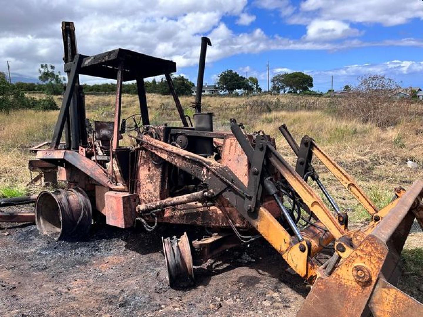 A photo of the charred frame of a tractor.