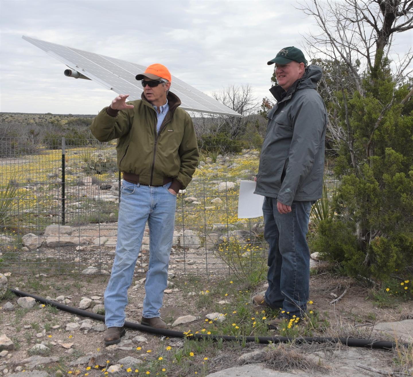 (L-R) 7 Oaks Ranch owner Wayne Walker and NRCS Ozona district conservationist Chris Wolfenbarger stand in front of a solar pane; that supplies water to the ranch. They discuss plans for future expansion of the water system.