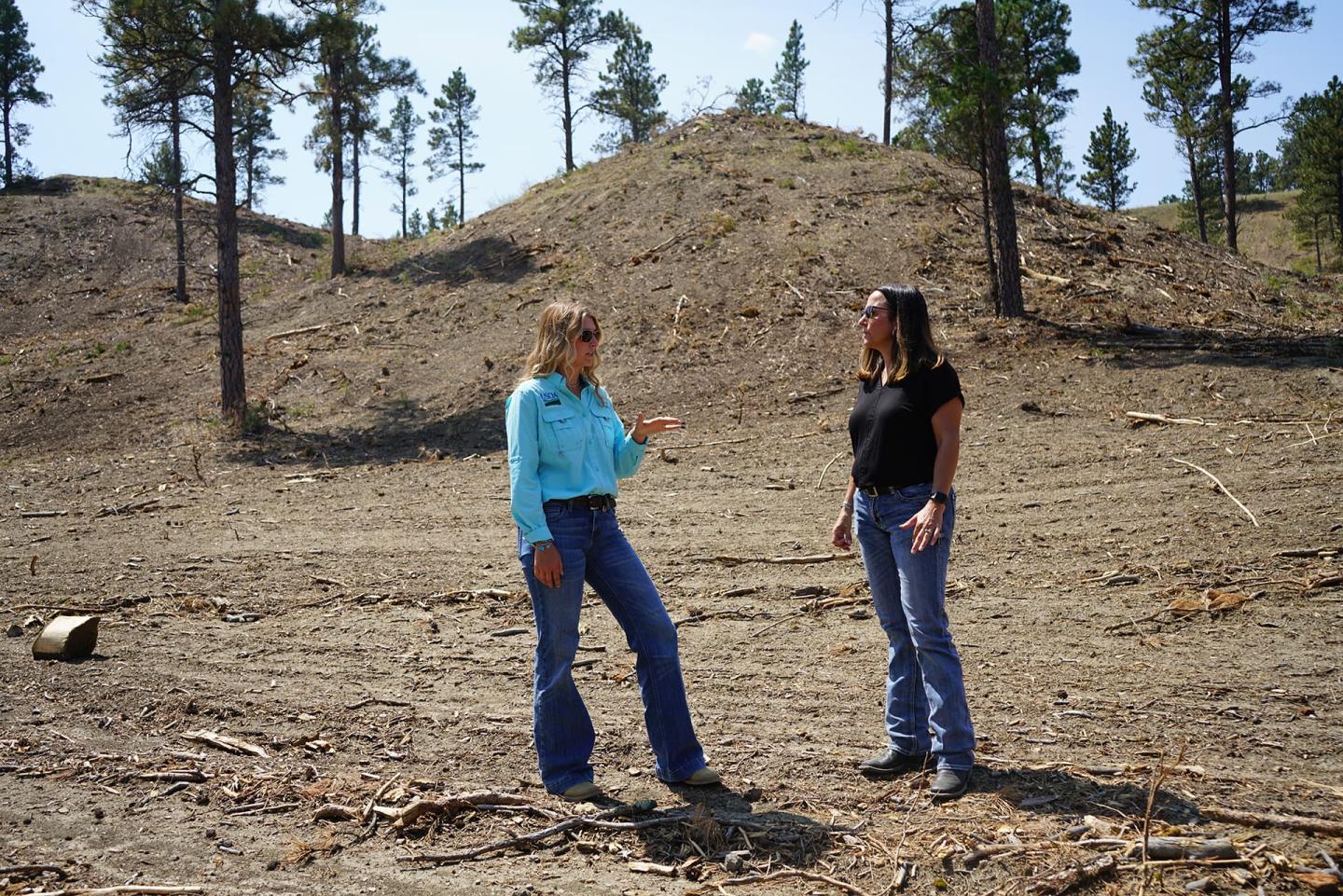 Kaci Anderson, NRCS soil conservationist, and Staci Ketchum, landowner, stand in an area treated to reduce conifer encroachment in Custer County.