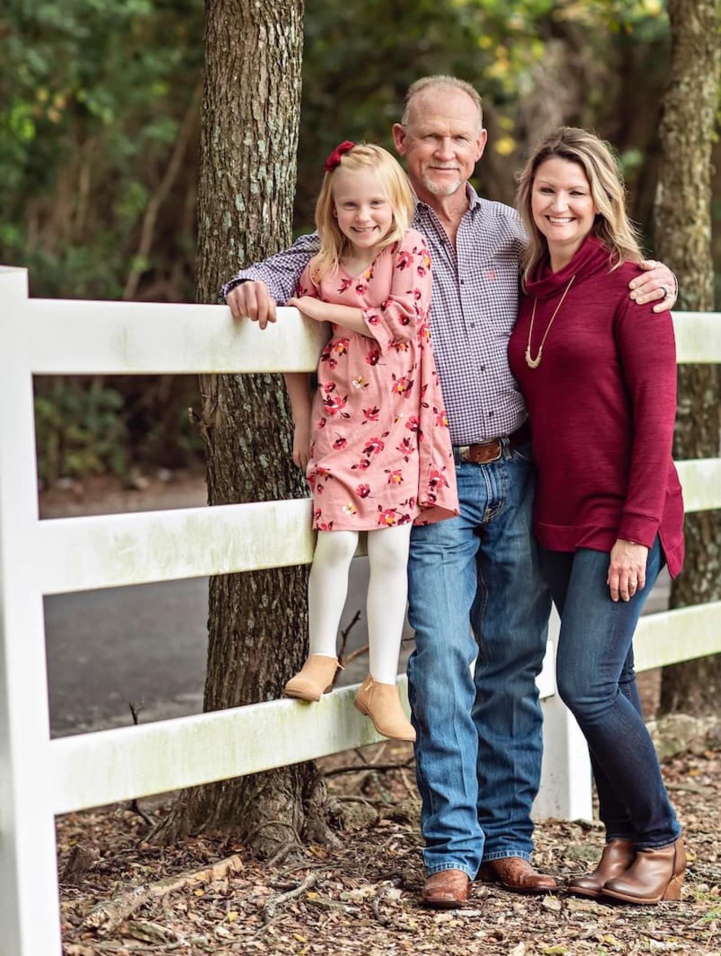 Chuck Emerson in the center with daughter Carsyn on the left and wife, Carol on the right standing next to a fence on their 720 acre farm that sits between Belton and Little River-Academy in Central Texas.