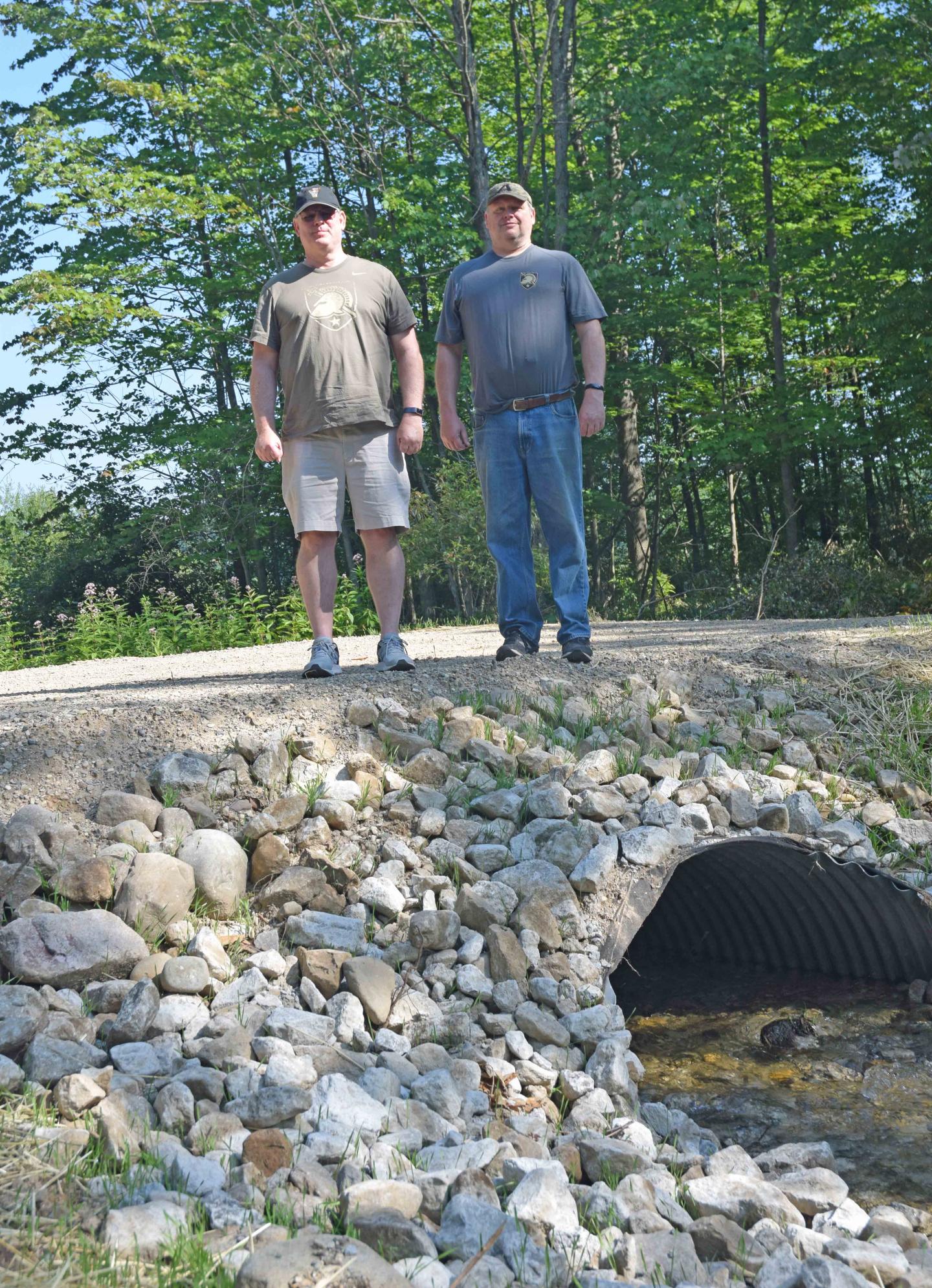 Brothers John and Robert Simmons stand above a fish passage constructed on their farm in Kent County.