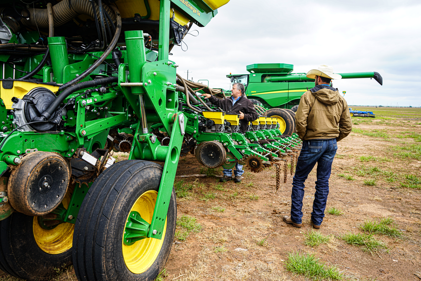 Two men look at single pass no-till drill and planter.