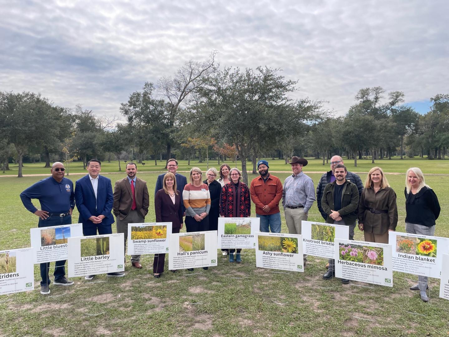 This is an image of the Regional Access To Native Seed Mix coalition standing with posters for the plant releases that were accepted for use in the Harris County Flood Control District plantings.