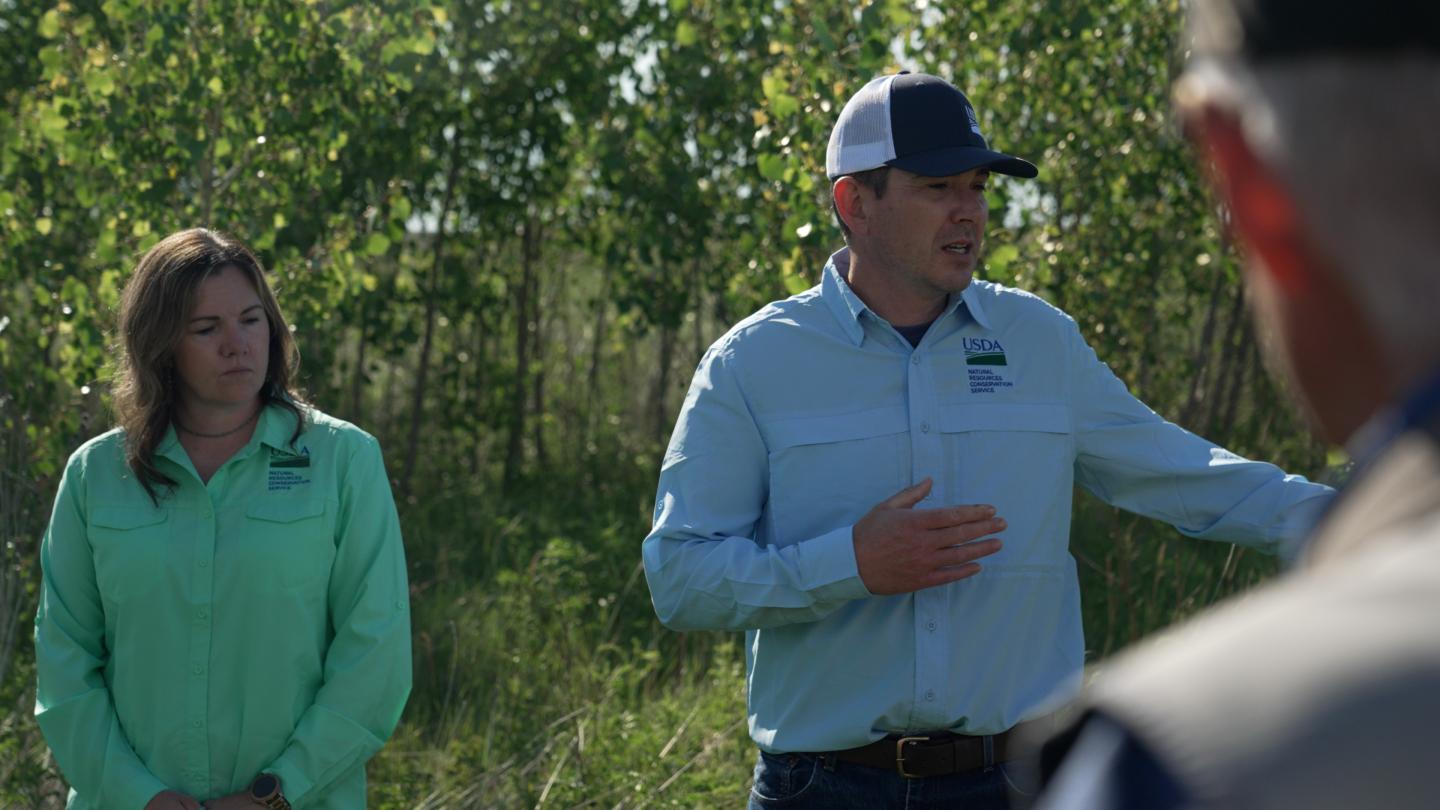 Two people standing in field talking