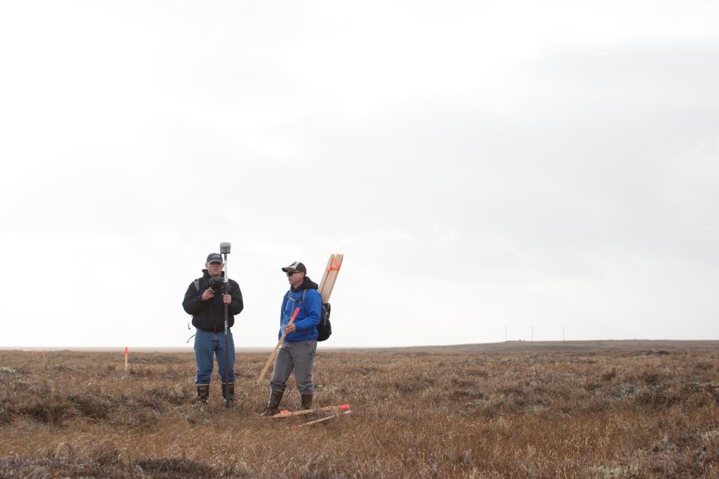 two people standing on the tundra in Alaska with engineering equipment