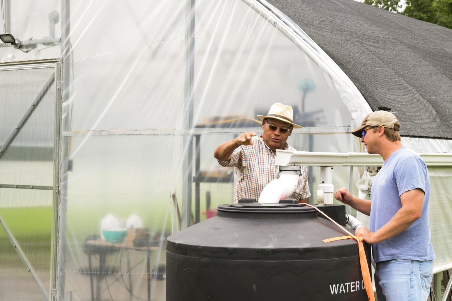 Two men and a water collection reservoir