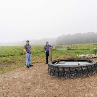 Indiana NRCS district conservationist Thomas Perkins (left) and Jerry Bates inspect a watering facility at Bates' beef cattle operation in Cloverdale, IN.