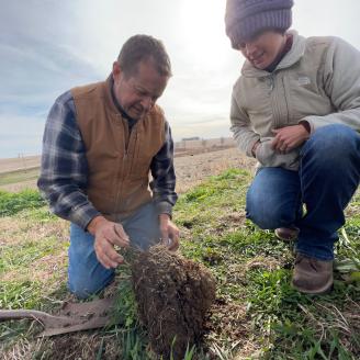 Male and Female inspect soil's health in Iowa.