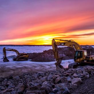 Two bulldozers move rock material in Galena, Alaska.
