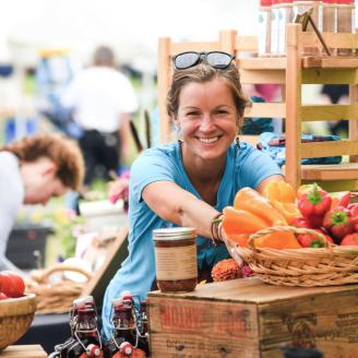 Woman working at a farm stand smiling