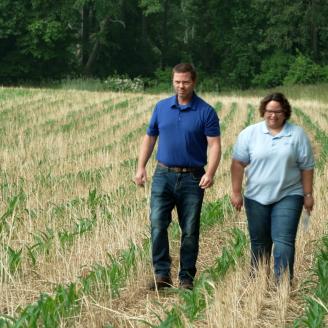 Vineland District Conservationist Michelle Pedano walks through a wheat field with producer Mike Bonham.