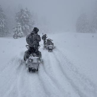 Riders on snowmobiles in wintry weather