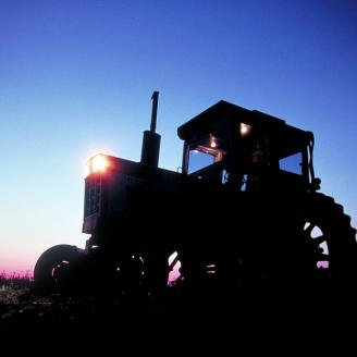 sun rising behind tractor