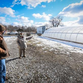 Aster Bekele, the founder of The Felege Hiywot Center in Indianapolis, Indiana, gives Jerod Chew, Indiana NRCS district conservationist, a tour of the center's high tunnel that was built in November 2020. The high tunnel was funded in part through the NRCS's Environmental Quality Incentives Program. (Indiana NRCS photo by Brandon O'Connor)