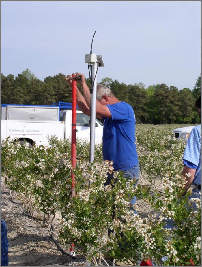 Man installing equipment in field