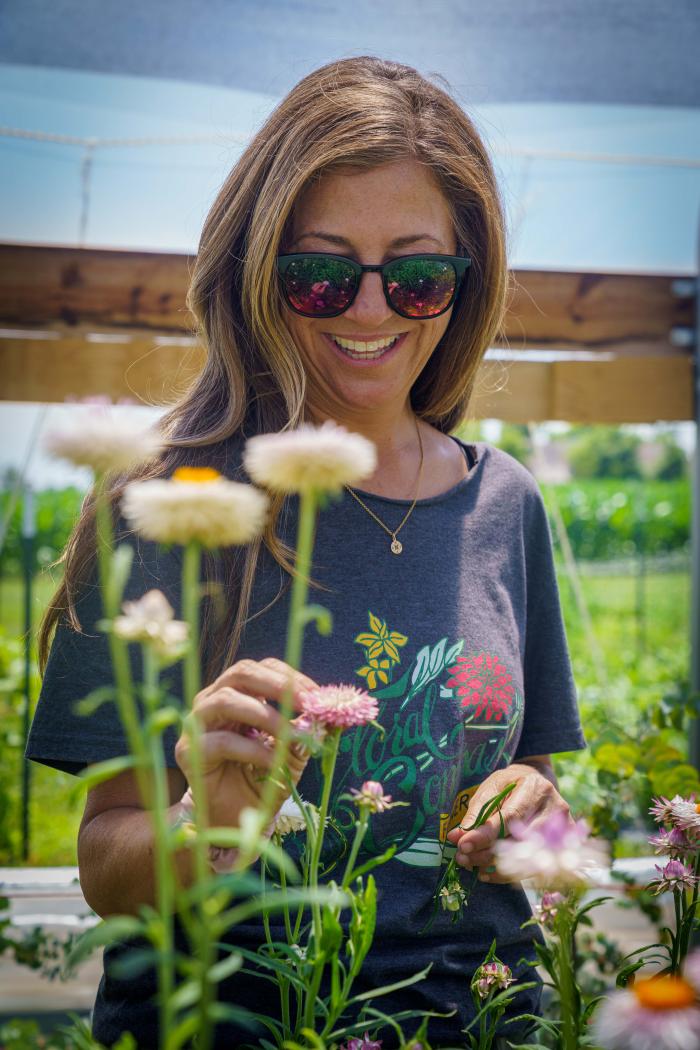 Carrie Kleiman, the owner of Floral Compass Flower Farm in Fountaintown, Indiana, tends to flowers in the farm’s high tunnel June 28, 2022.