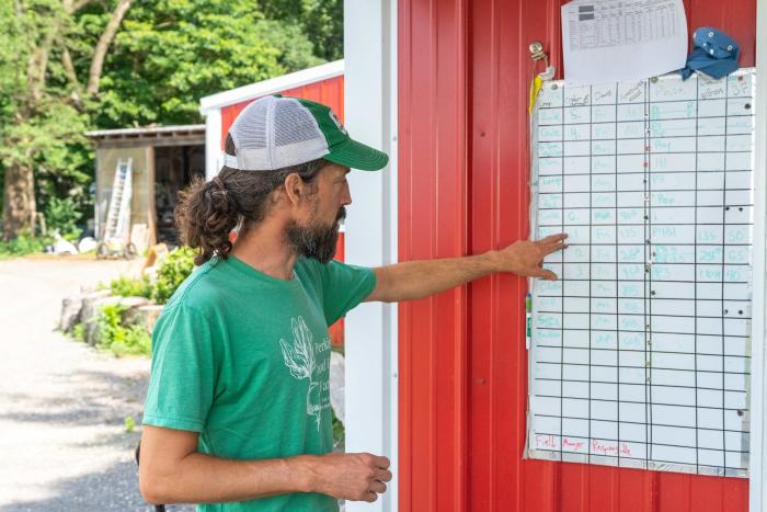 Dan Perkins, co-owner of Perkins' Good Earth Farm in DeMotte, Indiana, looks over the board the farm uses to track what produce is harvested on what days and the amounts.. The farm supports more than 200 local families through its four season CSA program and they recently added food and beverage options as well as products by other local producers to their farm stand. 

Perkins’ Good Earth Farm is a certified organic farm and Dan and Julie Perkins practice regenerative agriculture including no-till and co