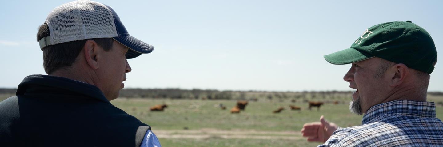 Cody Halfmann (left) and local NRCS employee Wade Day (right) talking