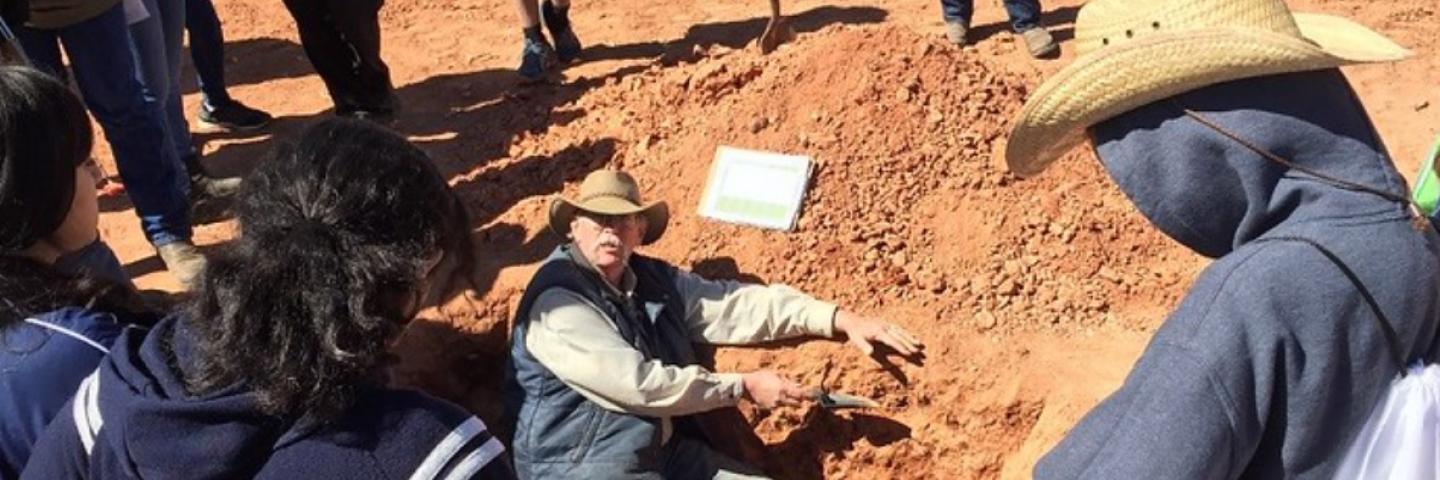 Soil scientist teaching students about soil