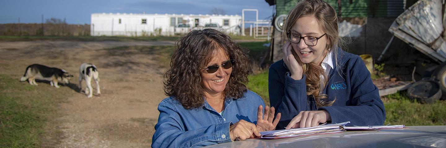 A farmer and an NRCS employee review a conservation plan.