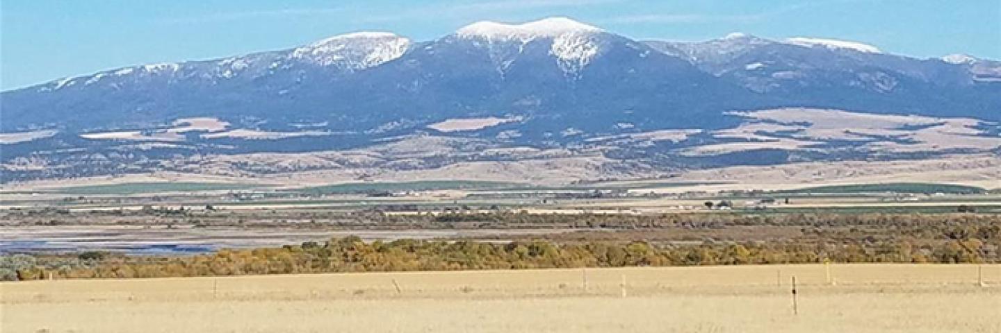 Scenic view of rangeland, treed valley, and mountains in Broadwater County, Montana