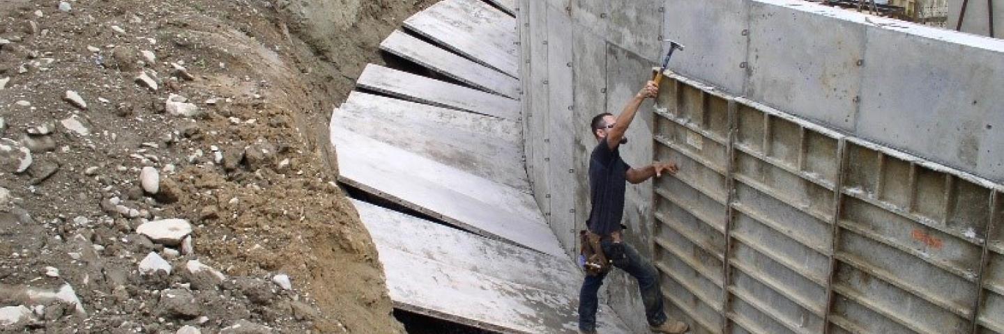 A engineer works on a project surrounded by dirt.