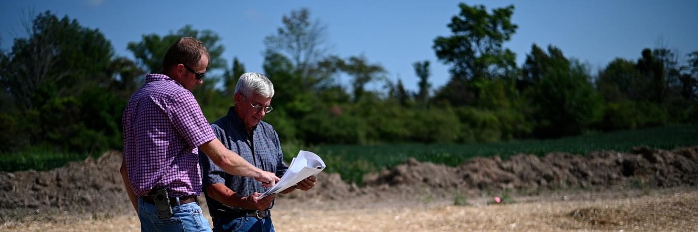 Engineer Greg Wells speaks to a landowner about grassed waterway technical standards