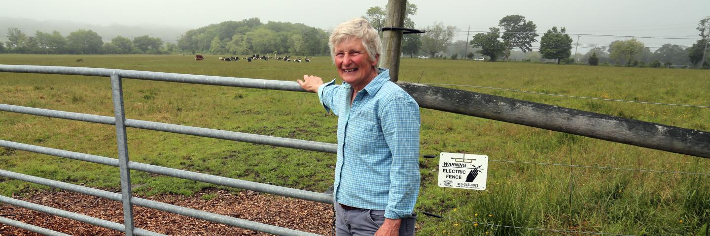 Farmer Martha Neal standing by a fence in a field.