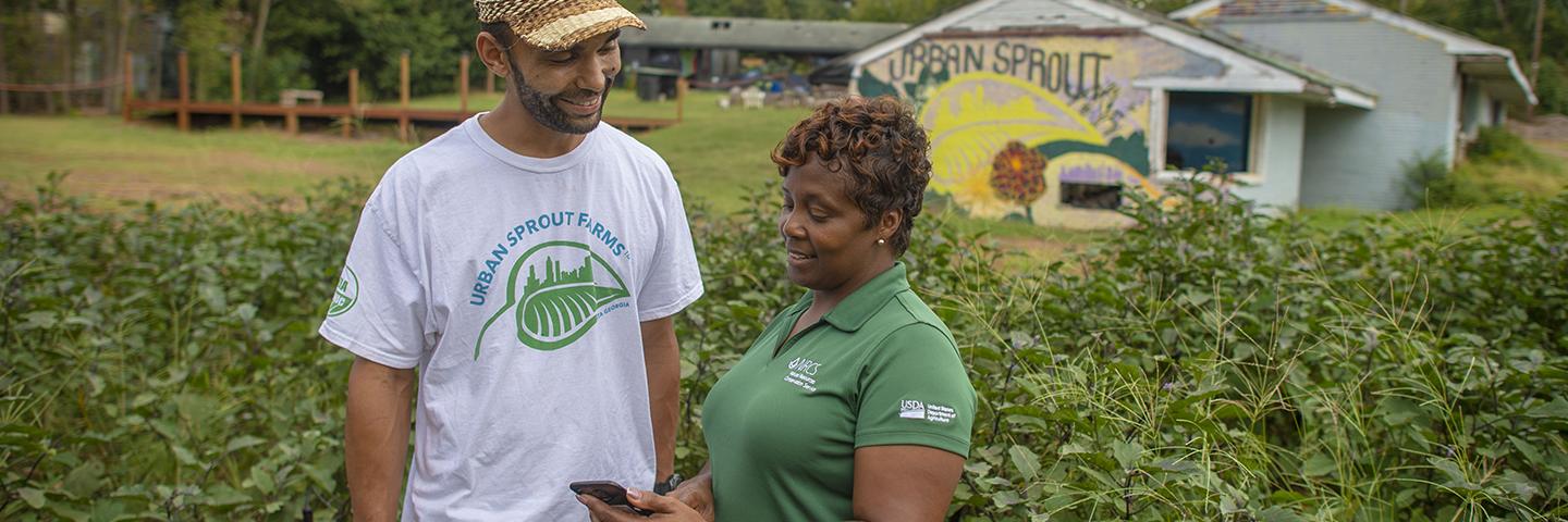 An urban grower meets with an NRCS conservationist.