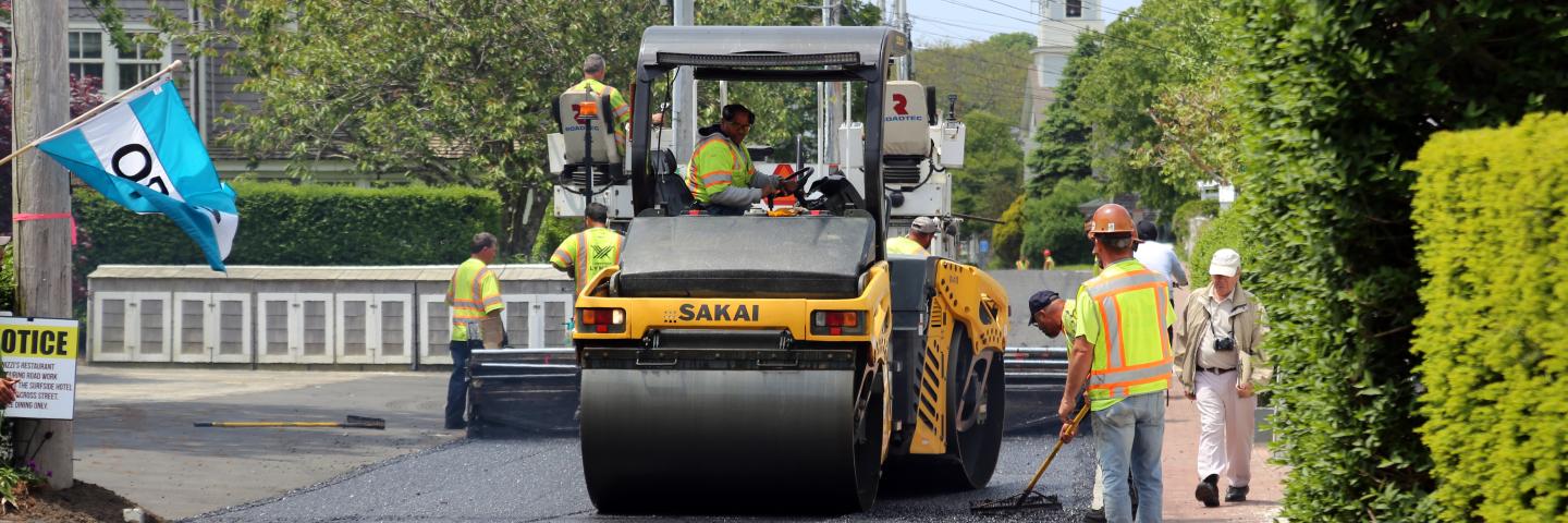 A roller-compactor rolls out porous asphalt on Commercial Street in Provincetown, Massachusetts.