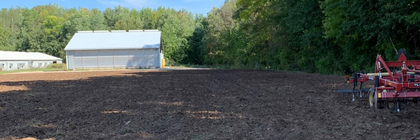 Finished grade over the closed manure storage facility site.