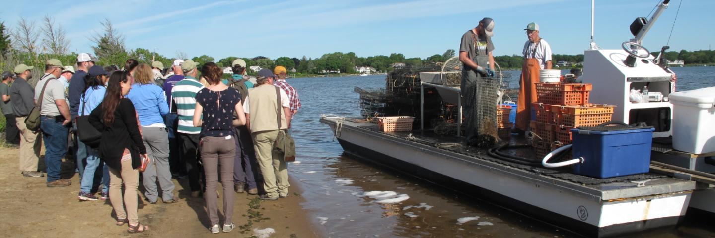 NCSS members view fishing boat on coast. 