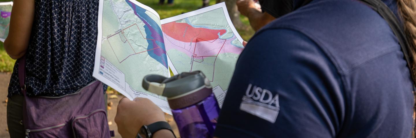 An NRCS employee examines a field map of a conservation property. 