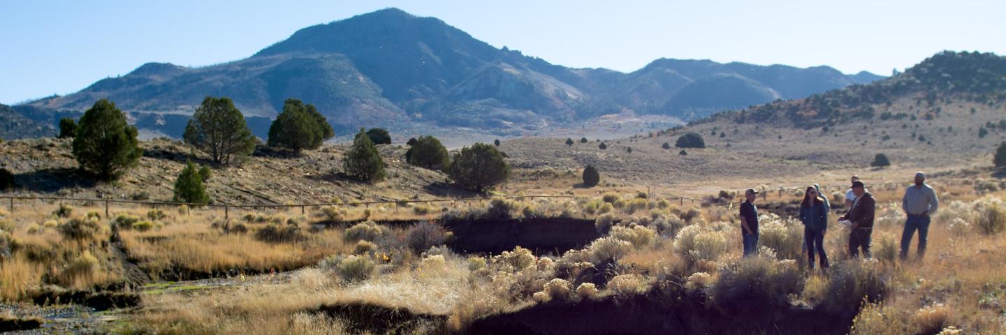 Several people on rangeland with mountains