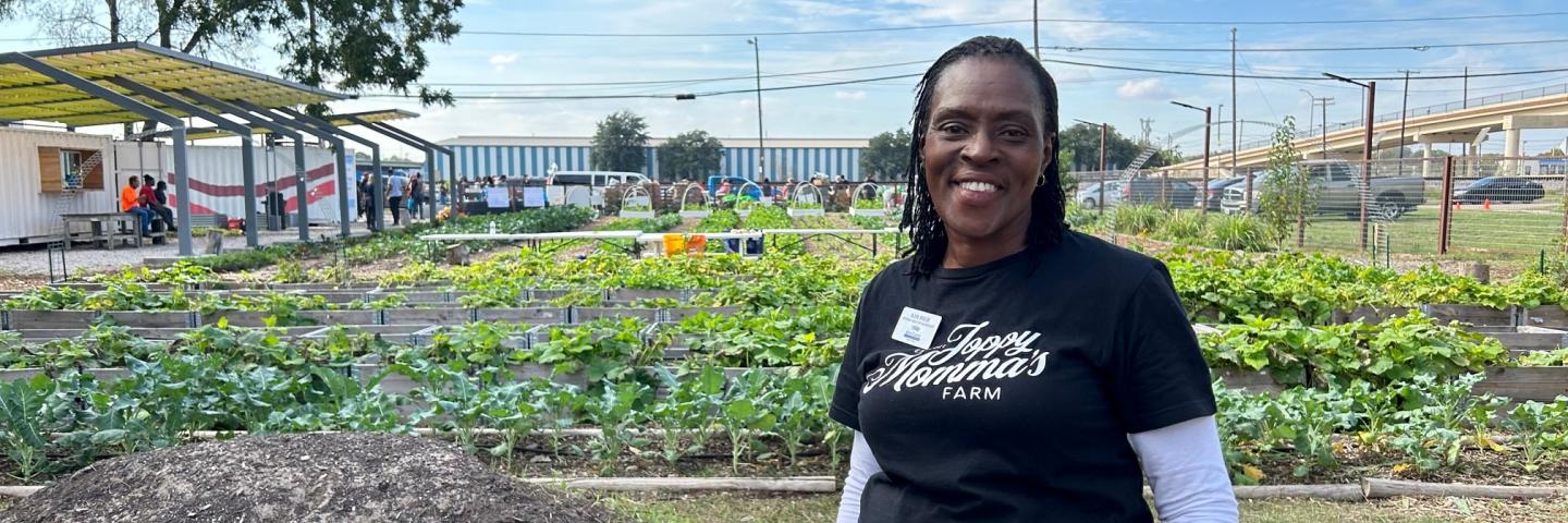 Kim High stands in front of urban garden