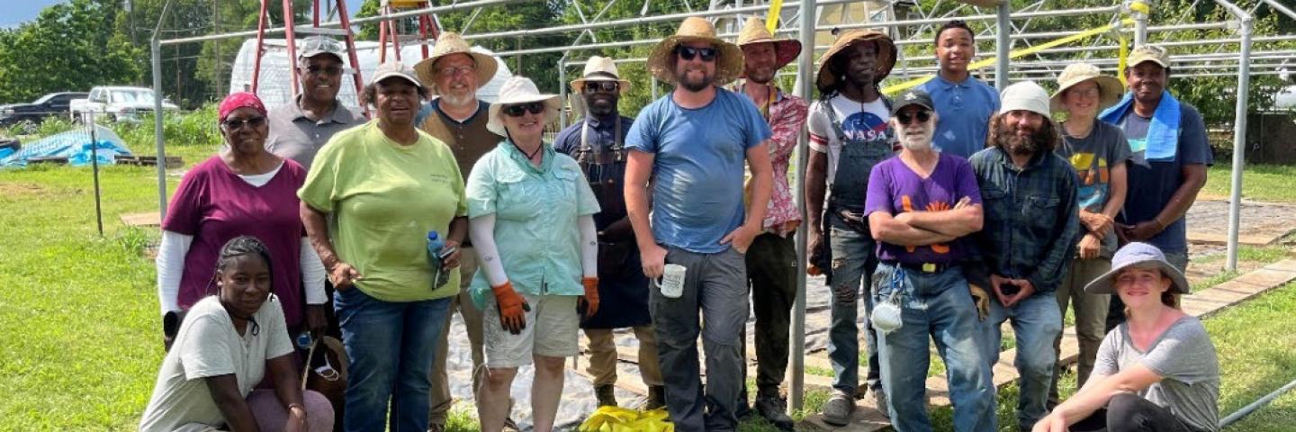 Group picture of volunteer farmers in front of their hoop house
