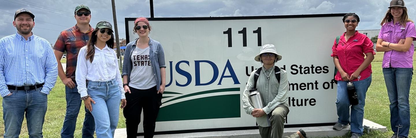 Summer interns at Lockhart NRCS field office in front of USDA sign