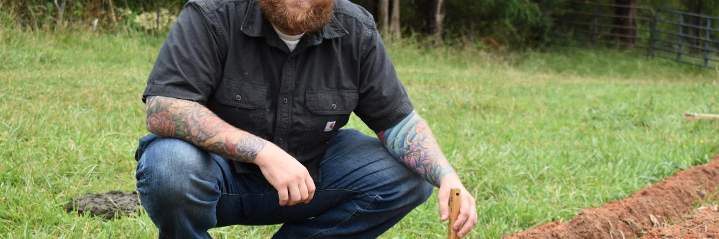 North Carolina farmer Justin Halama holding a measuring tool.