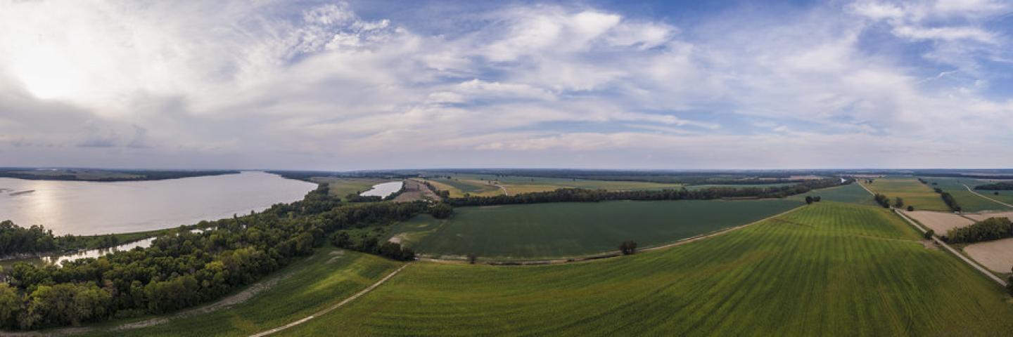 180 degree spherical aerial panorama of the Mississippi River flows in the foreground and it is not uncommon to see water flood the fields beyond where Charlie Roberts, owner of Roberts Farms focuses on utilizing conservation practices developed with the U.S. Department of Agriculture (USDA) Farm Production and Conservation (FPAC) Natural Resources Conservation Service (NRCS) to utilizes cover crops to prevent sheet, rill, and ephemeral gullies; and implementing soil health principals that improve soil heal