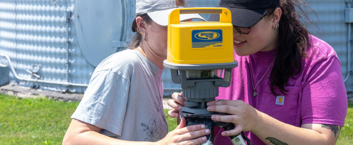 Two young women looking through a laser level