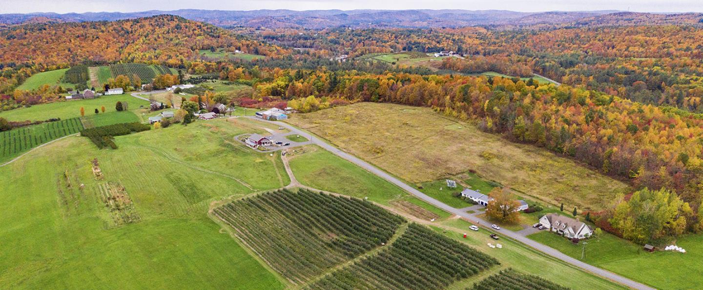 Aerial view of farm in hilly country; trees are in fall colors
