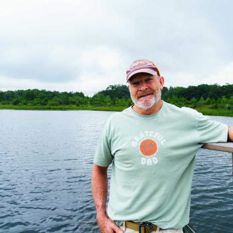 Tom Dykstra poses for a portrait over looking the main pond on his WRE site