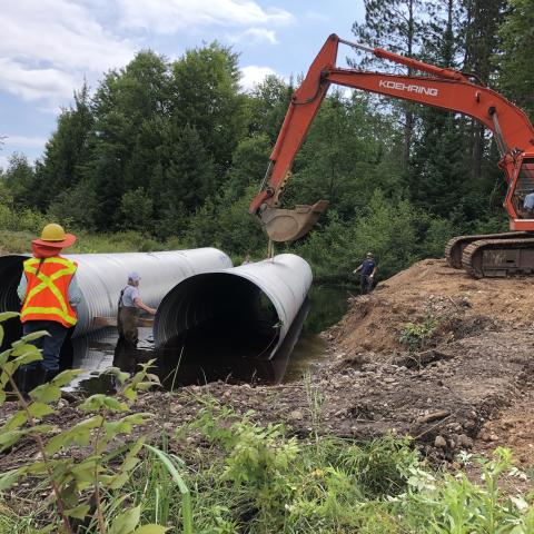 Pictured are the two 87” x 63” x 50’ aluminized steel arched culverts being placed in the stream bed. 