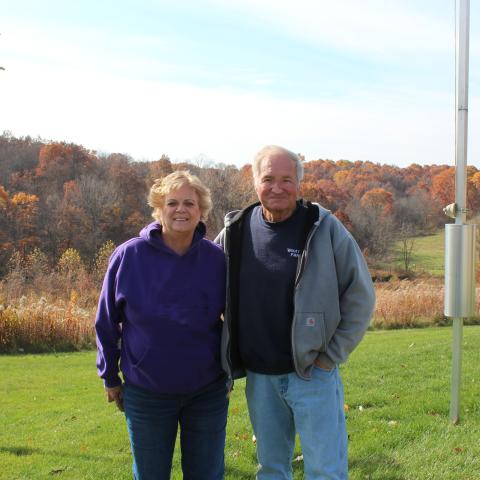 landowner and wife posing in front of conservation area