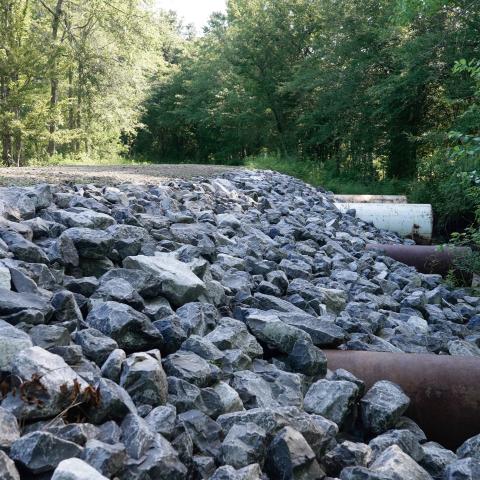 Medium-sized rock rip rap is one of the techniques used to stabilize the side slope of the county roadway in Jasper County, Texas.